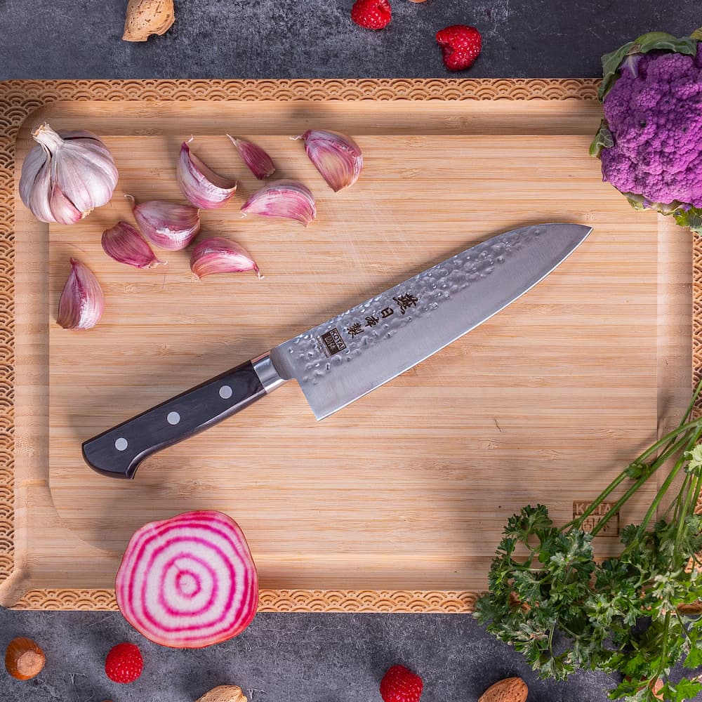 Couteau Santoku Tsubame Kotai Réunion sur planche à découper.