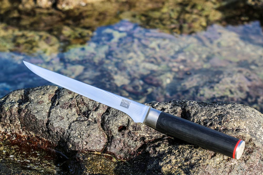 Couteau à filet Pakka Damas Kotai Réunion sur la roche